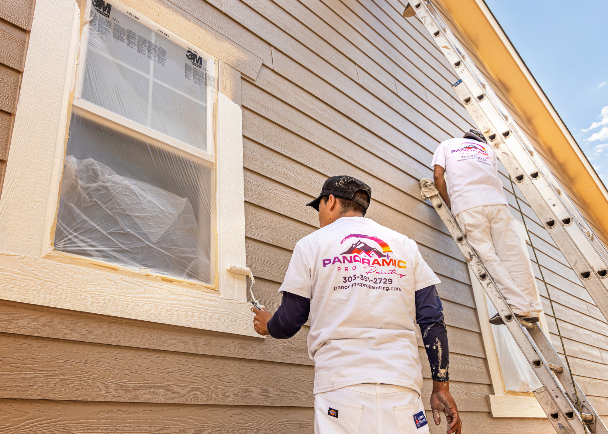 Professional painters painting a two-story home exterior