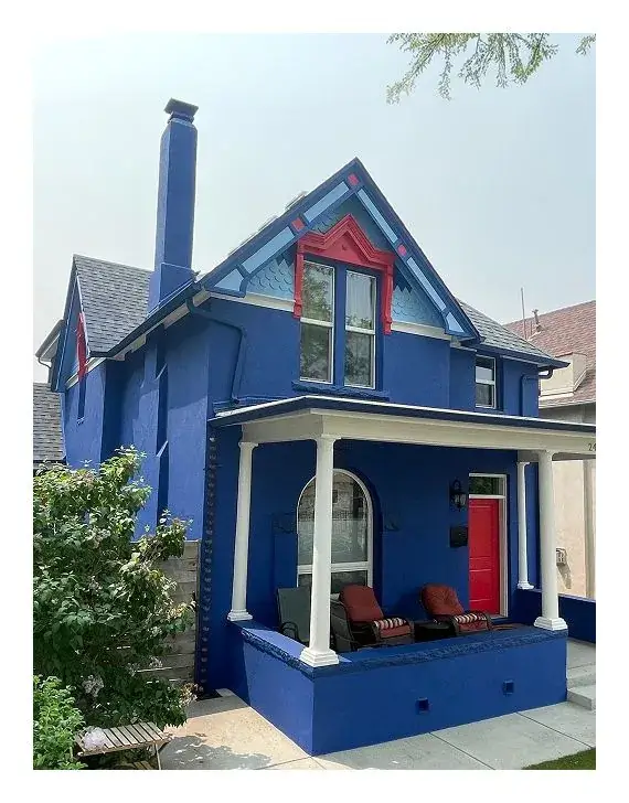 Victorian home exterior painted in bold royal blue with red accents by Panoramic Pro Painting Denver