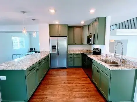 Kitchen cabinet painting in sage green with granite countertops by Panoramic Pro Painting Denver