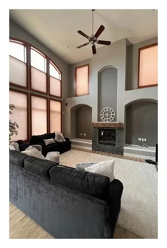 Interior living room painted in soft gray with vaulted ceilings and fireplace by Panoramic Pro Painting Denver